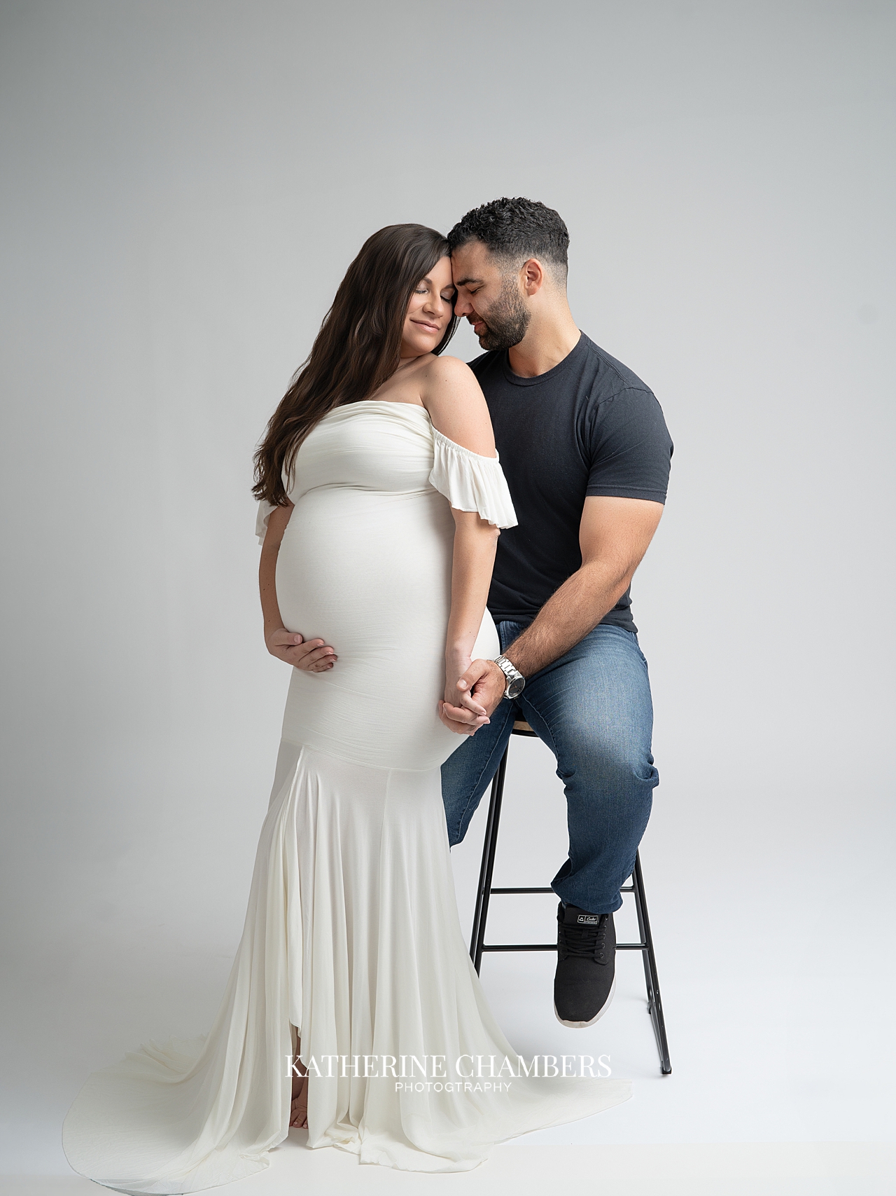 Husband and wife maternity portraits in studio setting
