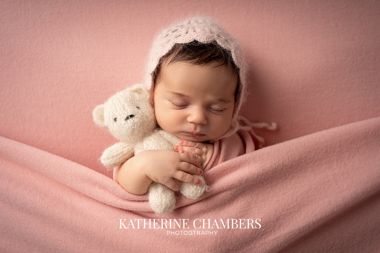 Baby girl holding stuffed teddy bear