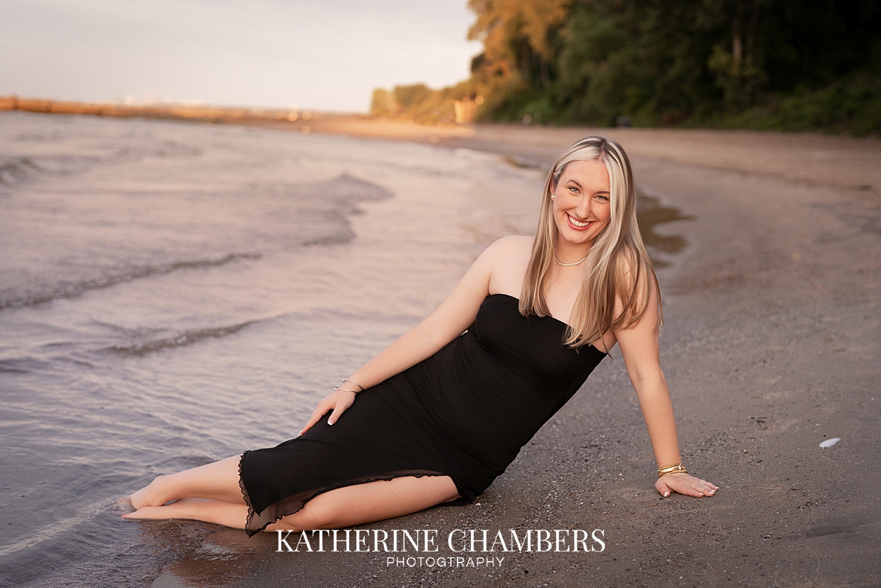 Senior girl sitting along the Lake Erie shoreline at sunset