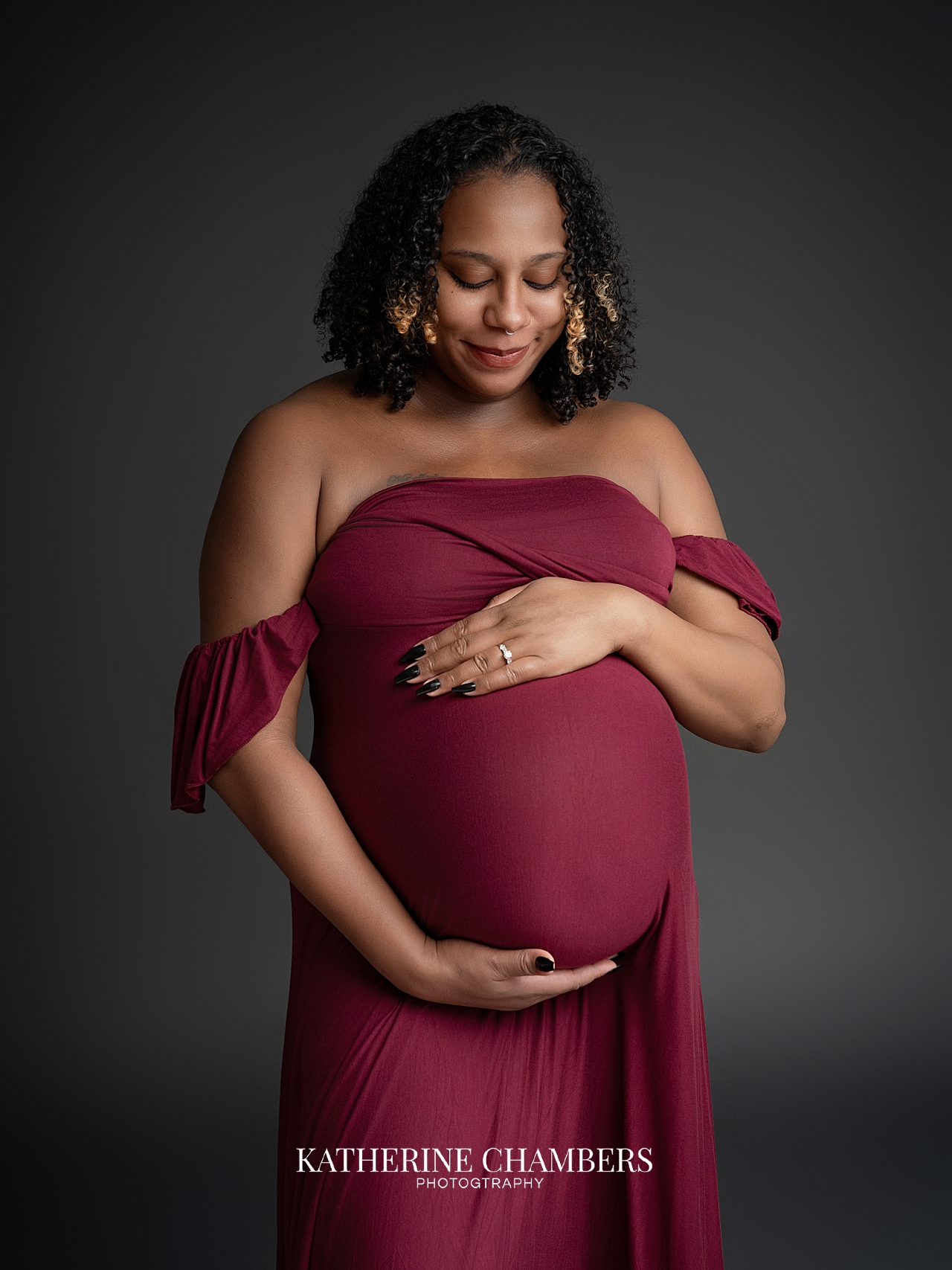 Pregnant woman wearing colorful red maternity gown in Cleveland studio session