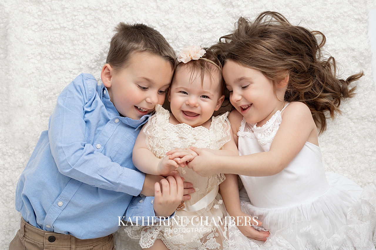 One year old girl with her older siblings