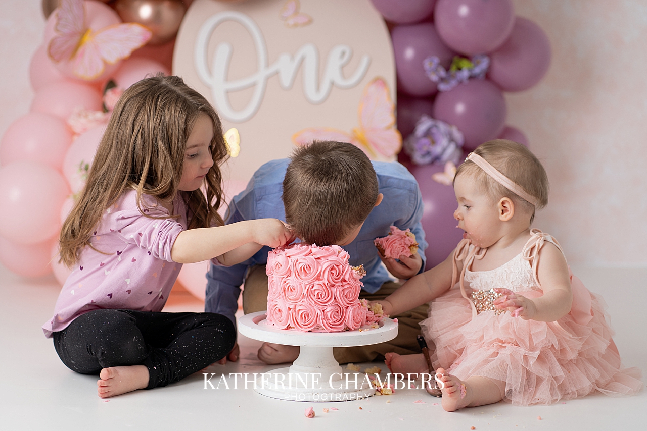 One year old girl cake smash with siblings