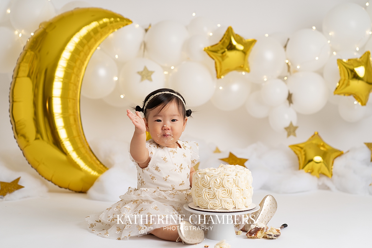 Seren waving with her birthday cake during her star themed cake smash