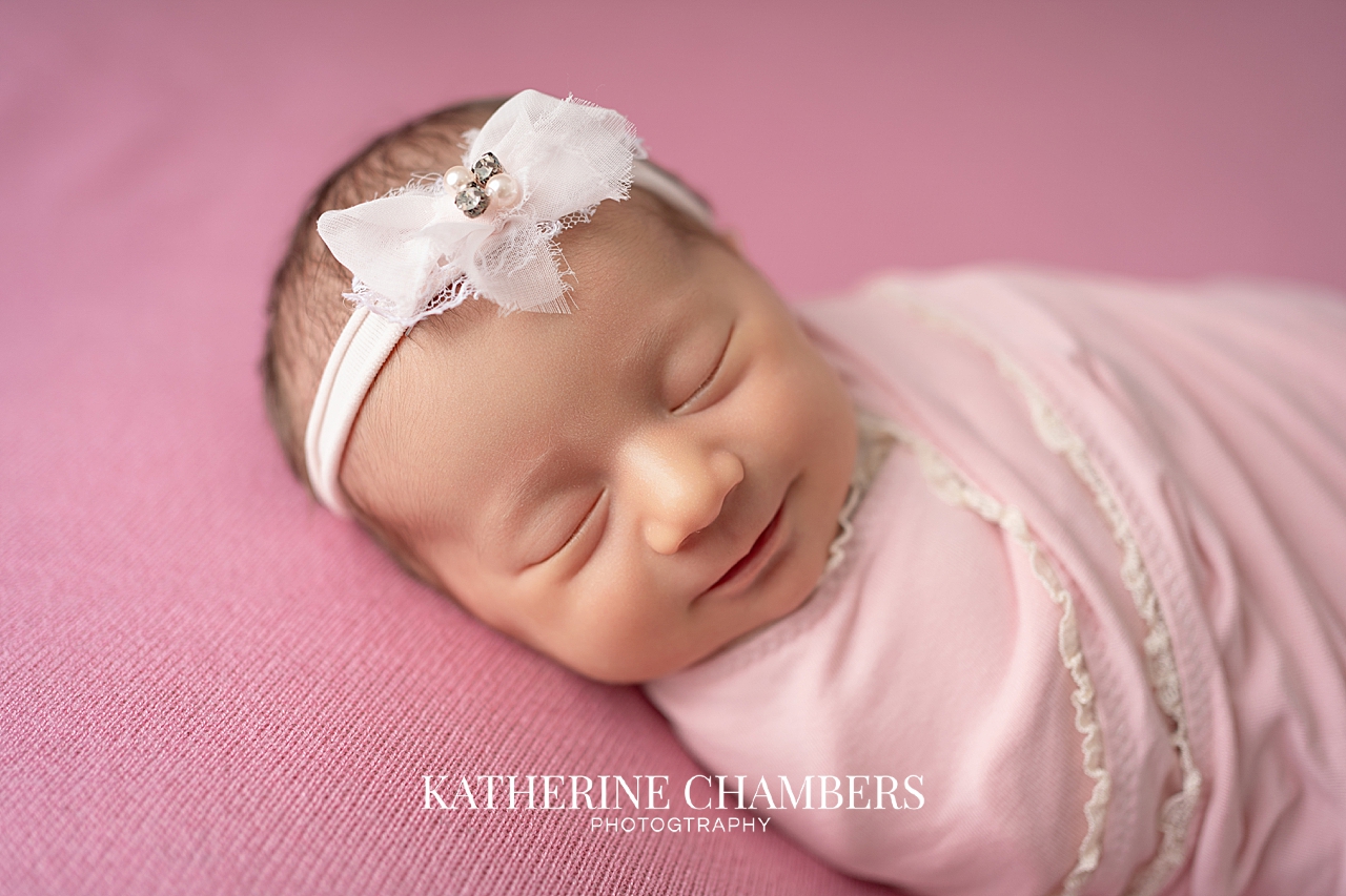 Newborn baby girl wrapped in pink blanket