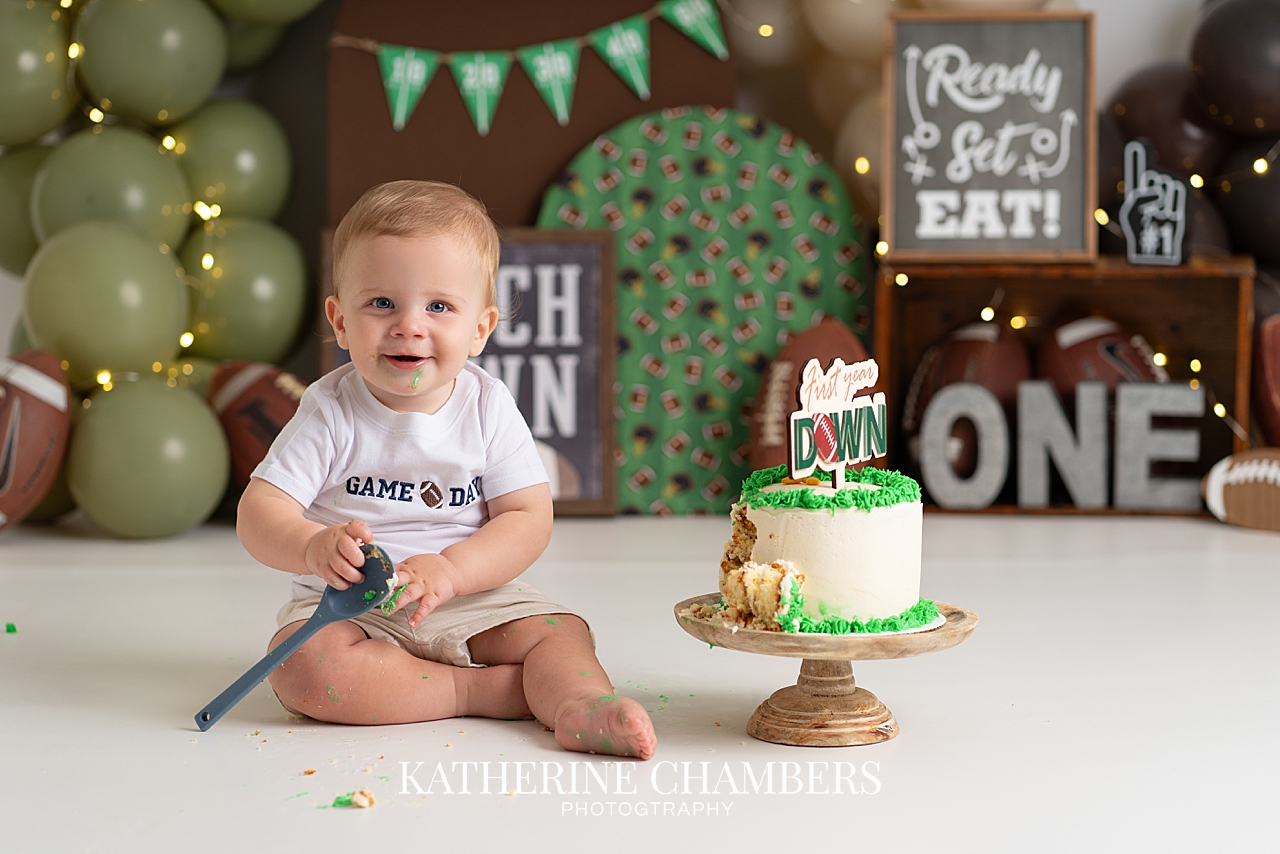 PJ celebrating his first birthday with a football-themed cake smash
