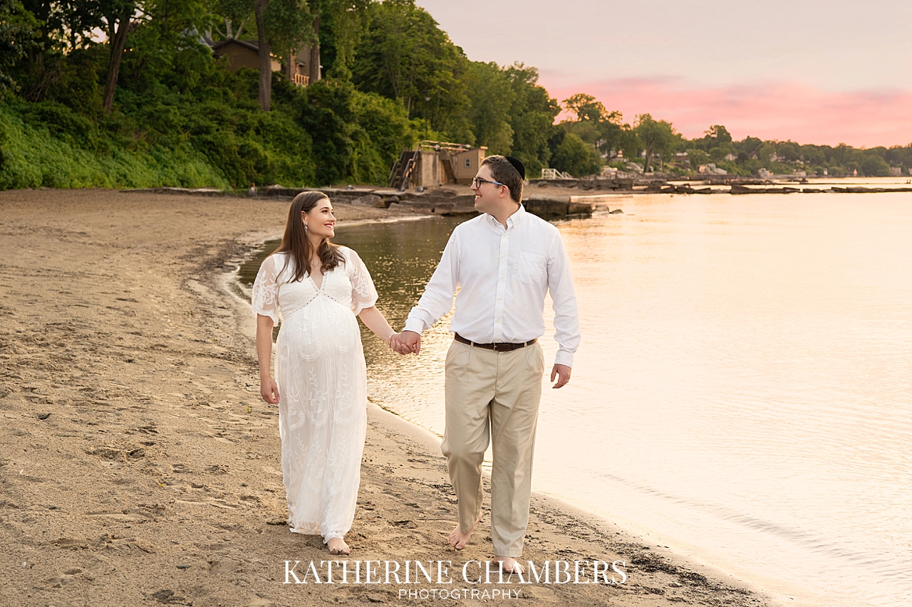 Expecting couple laughing together during Lake Erie maternity session